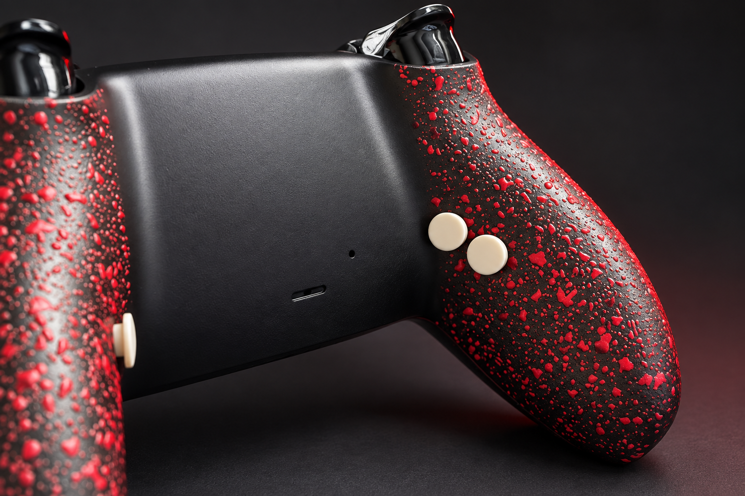 Gros plan de deux petits boutons arrière ronds blancs sur une coque noire avec grip rouge